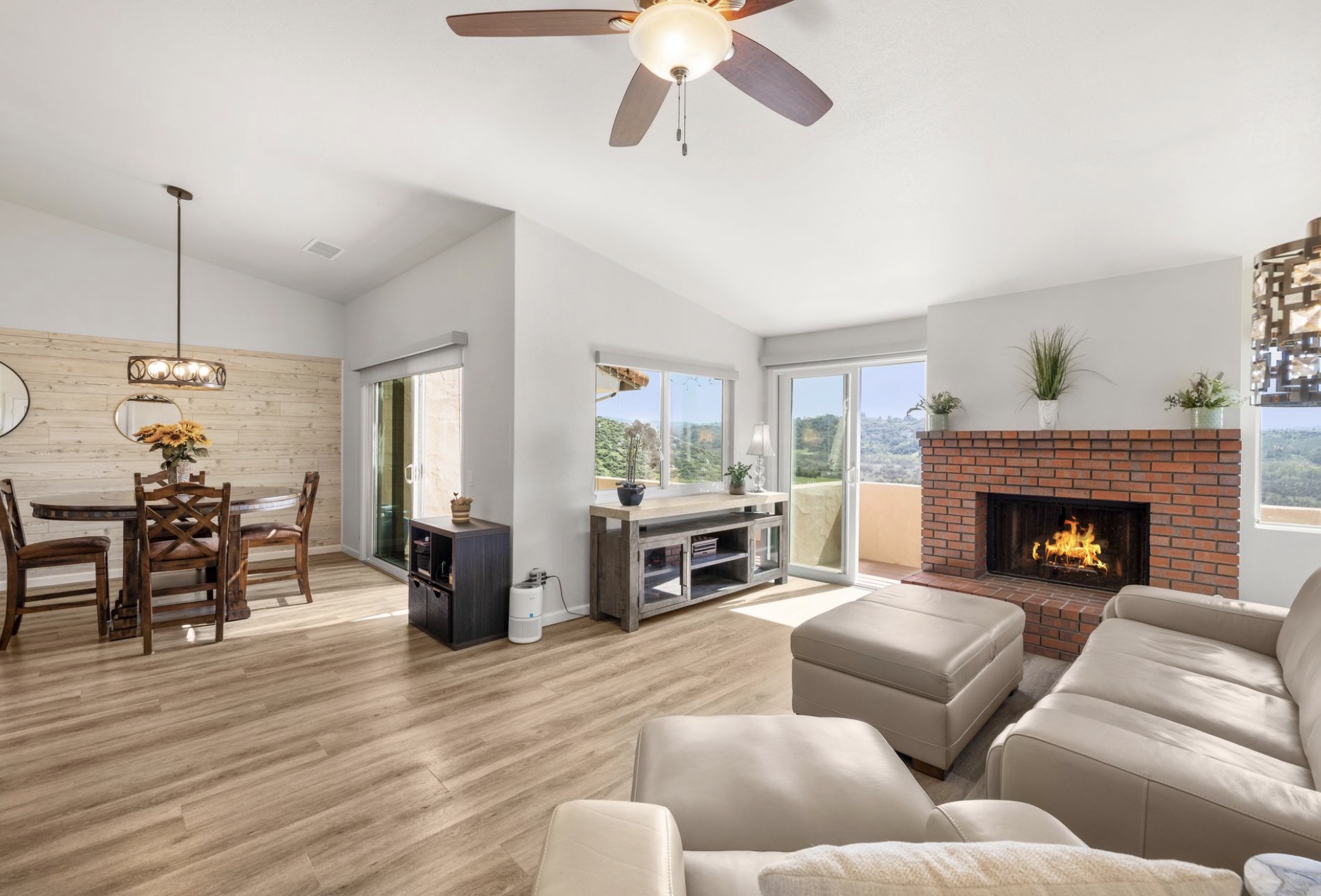 Living room with brick fireplace, wood flooring, and panoramic views