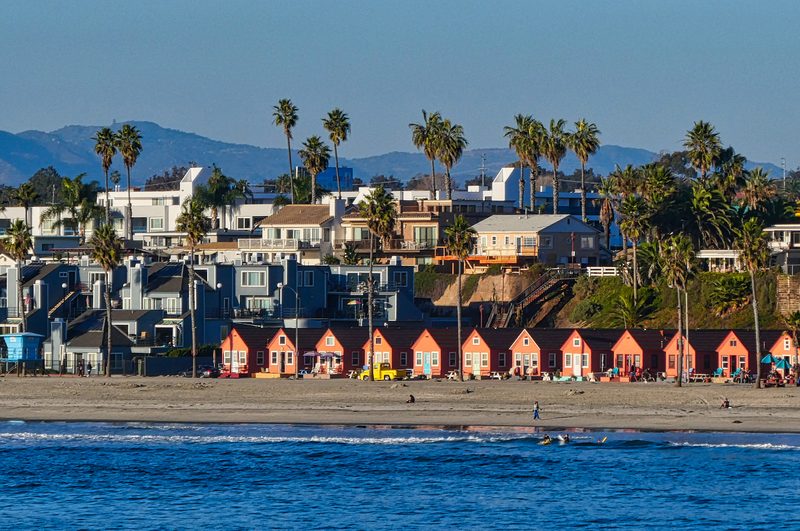 Oceanside beachfront homes with colorful cottages and palm trees