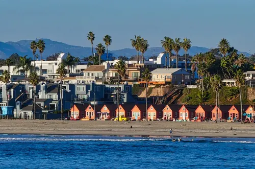 Oceanside beachfront homes with colorful cottages and palm trees